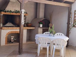a table and chairs in a kitchen with a fireplace at Villa Michalis in Katalagárion