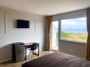a bedroom with a bed and a desk and a large window at Villa Megdani A in Ohrid