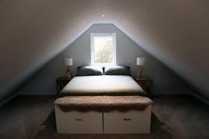 a bedroom with a bed in a attic with a window at Eco-Lodge by Golf Course in Colinsburgh