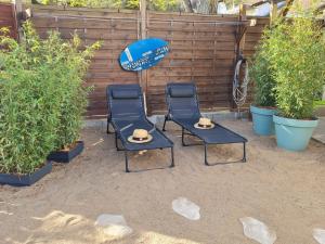 2 sillas y una sombrilla en el patio en Maison location Saint Brévin l'Océan, en Saint-Brevin-les-Pins