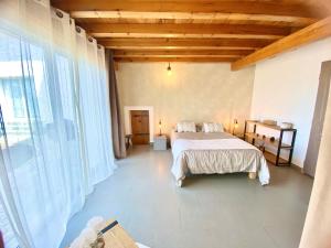 a bedroom with a bed and a large window at Chambres d’hôtes A Casa Di Marigaby in Barbaggio