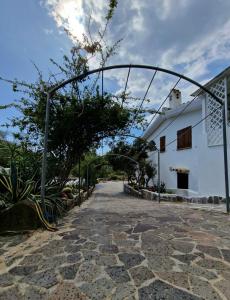 an archway over a stone path next to a white building at Villa Quattro Archi in Geremeas