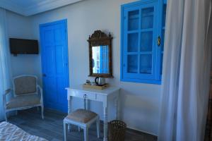 a blue room with a table and a mirror and a chair at Bellapais Abbey Boutique Hotel in Kyrenia