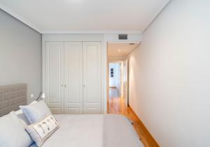 マドリードにあるAyala Apartment by Flatsweethomeの白いベッドルーム(ベッド1台付)、廊下