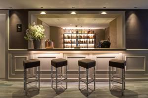 a bar with black stools in a room at Catalonia Square 4* Sup in Barcelona