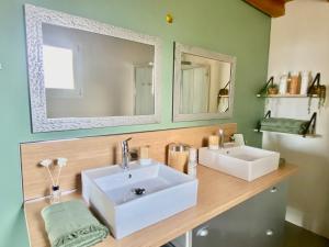 a bathroom with a white sink and two mirrors at Chambres d’hôtes A Casa Di Marigaby in Barbaggio