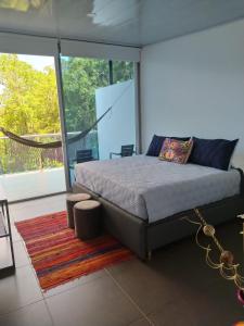 1 dormitorio con cama y ventana grande en Finca Pozo Azul en La Vega