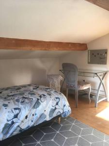 een slaapkamer met een bed, een bureau en een stoel bij Appartement avec jardin privé Gréoux les Bains au bord du Verdon in Gréoux-les-Bains