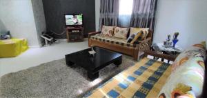 a living room with a couch and a coffee table at Villa Mimosa Tataouine in Tataouine