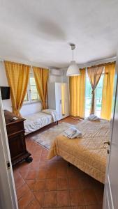a bedroom with two beds and a desk and windows at B&B Luna Nuova in Sarzana