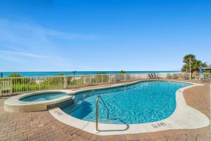 a swimming pool with the ocean in the background at Seychelles 1007 in Panama City Beach