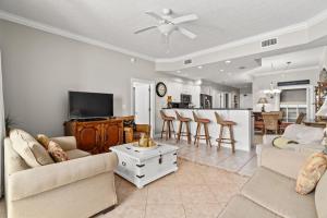 a living room with two couches and a kitchen at Treasure Island 0507 in Panama City Beach