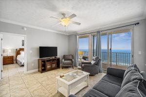 a living room with a couch and a tv at Treasure Island 1808 in Panama City Beach