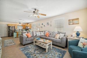 a living room with two couches and a table at Bellas Beach House in Panama City Beach