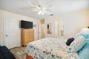 a bedroom with a bed and a flat screen tv at Bellas Beach House in Panama City Beach