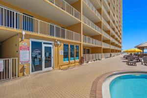 a building with a swimming pool in front of a building at Treasure Island 1802 in Panama City Beach