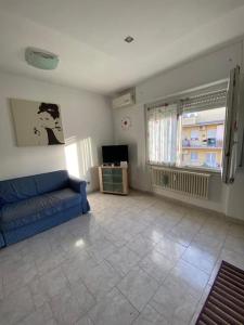 un salon avec un canapé bleu et une télévision dans l'établissement Vacanze Romane ~ Cozy Flat, à Rome