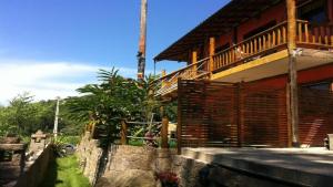 a building with a balcony on the side of it at Chalés Yababali in Ubatuba