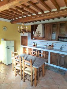 Villa Donnola: casa Rosmarino في فيوتشيتشيو: مطبخ مع طاولة وبعض الكراسي وثلاجة