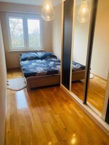 a bedroom with a bed and a large mirror at Przestronny apartament in Giżycko