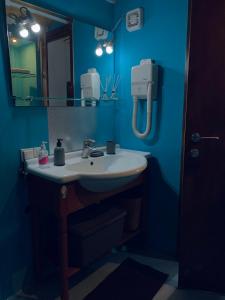 a bathroom with a sink and a blue wall at Loft Kapodistrias in Corfu