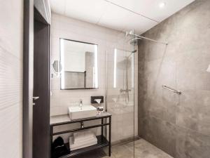 a bathroom with a sink and a shower at Mercure Bialystok in Białystok