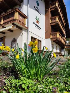 um edifício com flores amarelas em frente em Hotel Aquamarin em Bad Mitterndorf