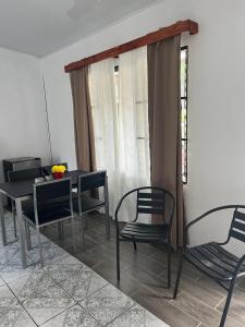 a dining room with chairs and a table and a window at Buganvilla No 4 in Quepos
