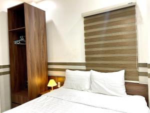 a bedroom with a bed with a wooden headboard at Shine Hotel in Hue