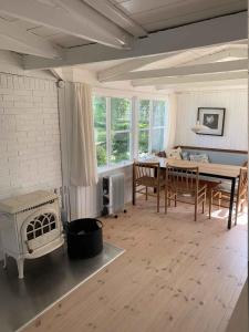 een woonkamer met een tafel en een fornuis bij Traditional Danish Summer House in Hornslet