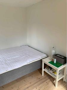 a bedroom with a bed and a small table at Traditional Danish Summer House in Hornslet
