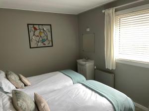 1 dormitorio con 2 camas y ventana en Delightful Annexe Apartment in St Andrews - Free Parking, en St Andrews