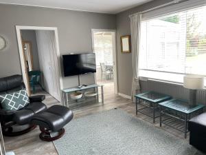 sala de estar con sofá y TV en Delightful Annexe Apartment in St Andrews - Free Parking, en St Andrews