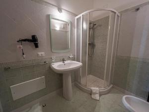W łazience znajduje się umywalka oraz prysznic z lustrem. w obiekcie B&B Sulmare w mieście Marettimo