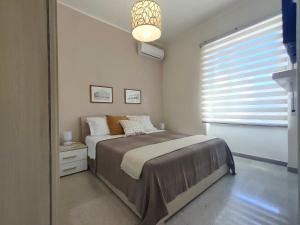 een kleine slaapkamer met een bed en een raam bij Ciauru i mari - Elegante appartamento Ortigia in Siracusa