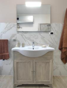 een badkamer met een wastafel en een spiegel bij Ciauru i mari - Elegante appartamento Ortigia in Siracusa
