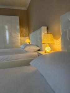 um quarto de hotel com duas camas e um candeeiro em SaEl Apartments em Shkodër