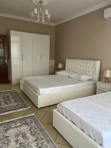 a bedroom with two beds and a chandelier at SaEl Apartments in Shkodër