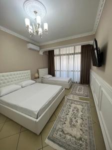 a bedroom with two beds and a flat screen tv at SaEl Apartments in Shkodër