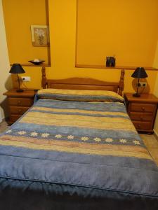 エスカロナにあるApartamentos Casa Modestoのベッドルーム1室(ベッド1台、ナイトスタンド2台、猫1匹付)