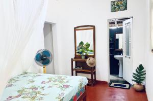 a bedroom with a bed and a mirror at Kingsley Place in Dickwella
