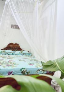 Kingsley Place في ديكويلا تين: غرفة نوم بسرير مع مظلة