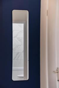 espejo en una pared azul en el baño en Super Central Studio Apartment I Next to Brighton Beach & Shopping Centre I KING SIZE BED I SLEEP 3, en Brighton & Hove
