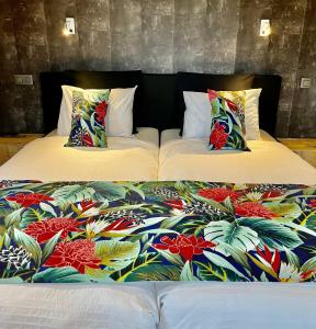 - deux lits avec des couvertures et des oreillers colorés dans l'établissement "Un matin au jardin", à Francorchamps