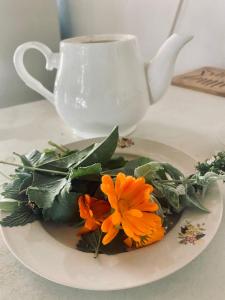 een bord met oranje bloemen en een kopje koffie bij Guest house on Akmatbai-Ata 29 in Cholpon-Ata
