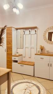 uma cozinha com armários brancos e um espelho em SaEl Apartments em Shkodër