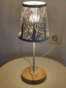 a lamp on a table with a tree on it at Nikόla's House in Mourniaí