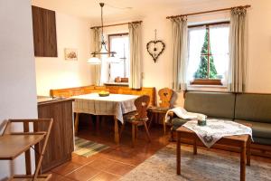 eine Küche und ein Wohnzimmer mit einem Tisch und Stühlen in der Unterkunft Ferienwohnungen Kern in Aschau im Chiemgau