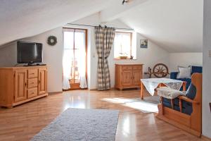 sala de estar con sofá y TV en Ferienwohnungen Kern, en Aschau im Chiemgau