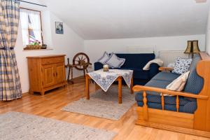 ein Wohnzimmer mit einem blauen Sofa und einem Tisch in der Unterkunft Ferienwohnungen Kern in Aschau im Chiemgau